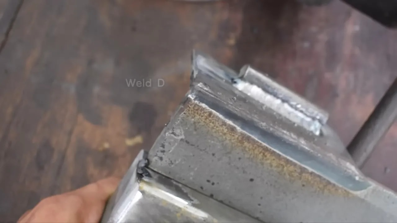 Close-up of a welded corner showing the weld bead profile, penetration and minor surface defects
